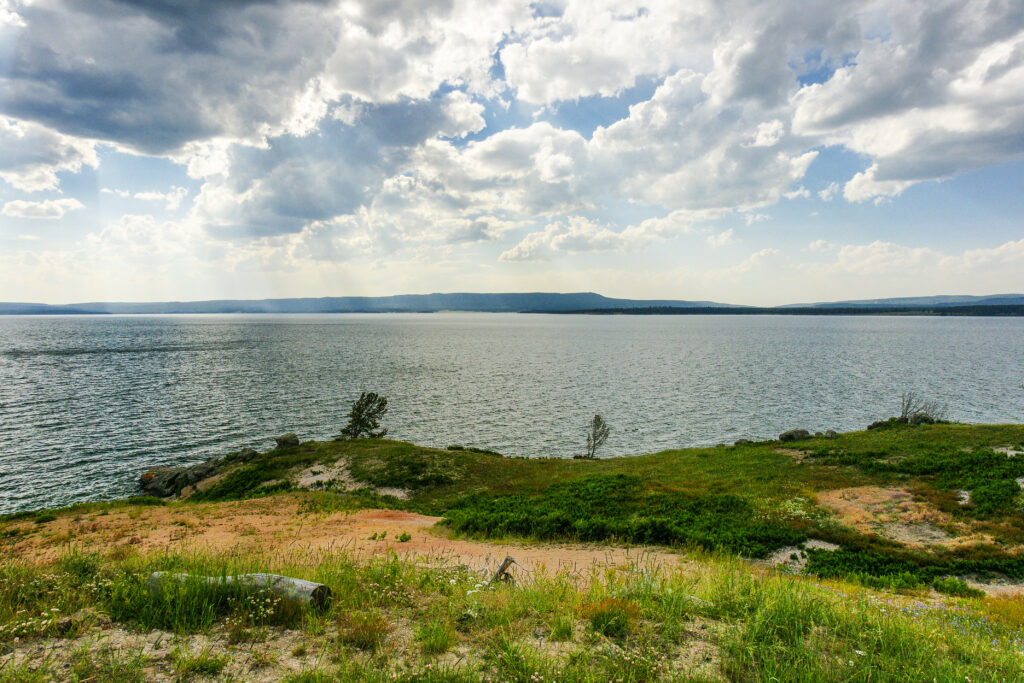 view of a body of water with low mountains or hills in the distance